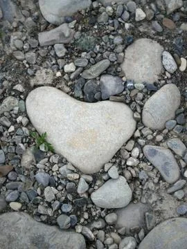 Abstract background a huge stone heart framed by large and small colorful peb Stock Photos