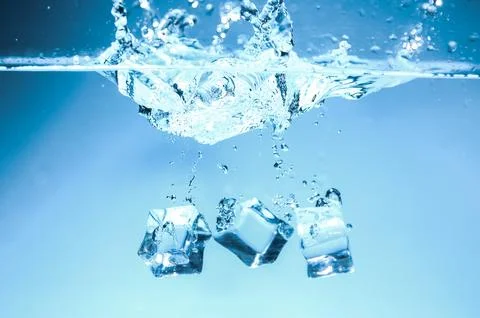 Abstract background image of ice cubes in blue water. Stock Photos