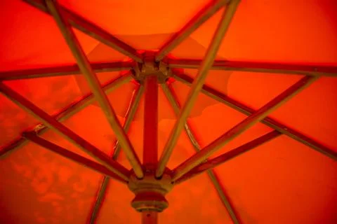 Abstract background of the inside of an orange umbrella with wooden supports. Stock Photos