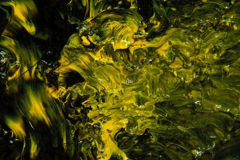 An abstract background of mixed black and yellow acrylic paint with a gloss.. 스톡 사진