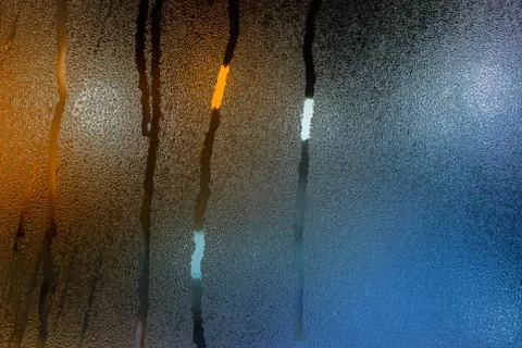 An abstract background of night wet window glass with smudges in teal-orange Stock Photos