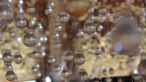 Abstract background of numerous glass light bulbs hanging on strings with soft b Video stock 319208959