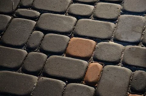 Abstract background of old cobblestone pavement close-up. Stock Photos