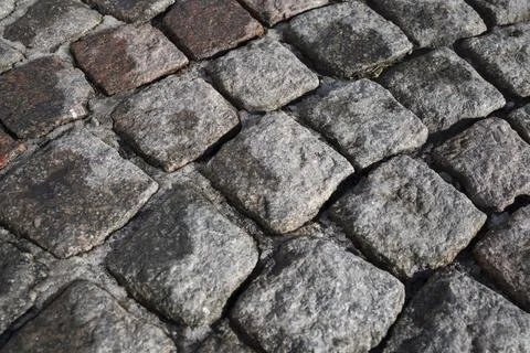 Abstract background of an old cobblestone pavement . Close up view Stock Photos