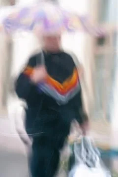 Abstract background of out of focus blurred lonely woman with umbrella near Foto stock