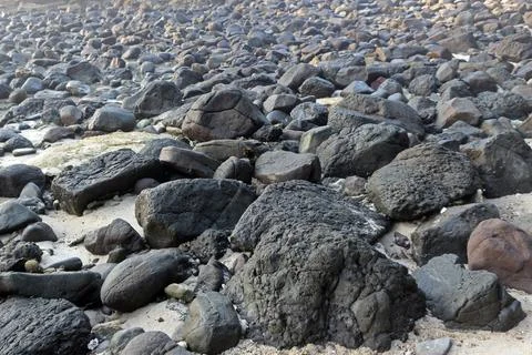 An abstract background of pebbles on the beach. Rocks texture and pattern w.. Stock Photos