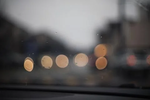 Abstract background with rainy car windshield and blurred city street light.. Stock Photos
