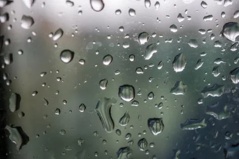 Abstract background showing a window with raindrops rolling off blue toned Stock Photos