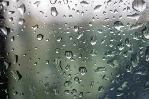 Abstract background showing a window with raindrops rolling off blue toned Stock Photos