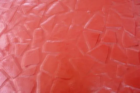 Abstract background with a textured red surface displaying irregular raised Stockfoto's