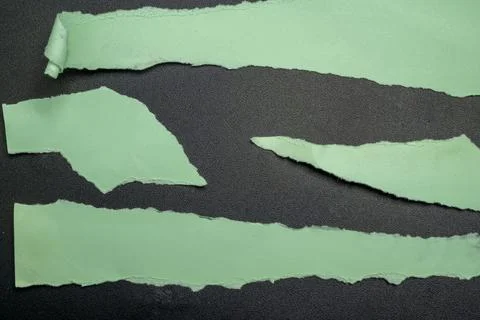 Abstract background of torn green construction paper strips scattered over .. Stock Photos