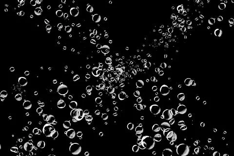 Abstract background of various sized bubbles floating on a black background.. Stock Photos