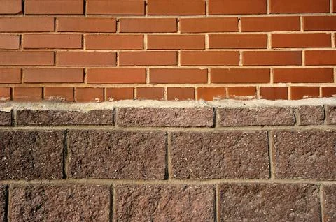 Abstract background of a wall of red brick, plaster, and stone veneer Stockfoto's