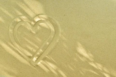 Abstract background with waves on the sand and a heart. Texture of beach sand Foto stock