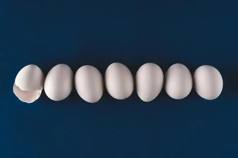 Abstract background of white eggs lined up on trendy dark blue backdrop. Easter 스톡 사진