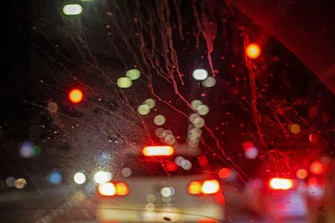 Abstract background of a windshield at night, red lighting, in a big city. .. Stock Photos