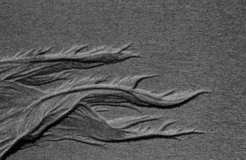 Abstract beach pattern formed by sand and water. Exotic forms of sand. Stock Photos