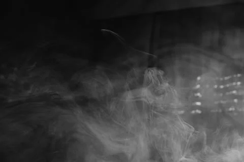 Abstract black and white background with wisps of white smoke swirling in d.. Stock Photos