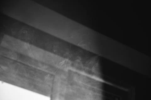 Abstract black and white image of wispy smoke drifting near architectural lin Stock Photos