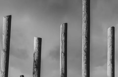 Abstract black and white pillars against cloudy sky Stock Photos