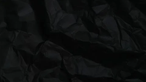 Abstract black background featuring a dark creased paper texture Stock Photos