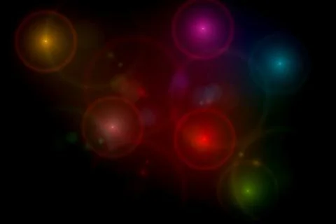 Abstract black background with multi color light flares Stock Photos