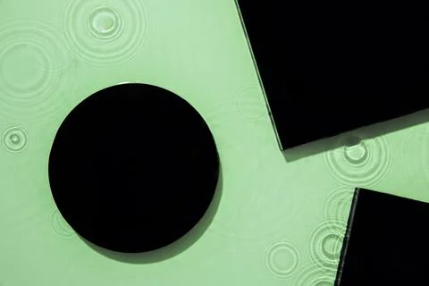 Abstract black geometric figures composition on transparent green clear water Stock Photos