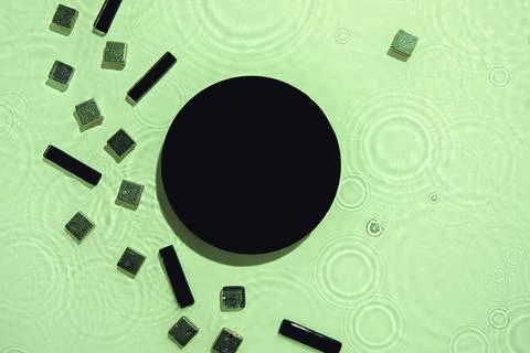 Abstract black geometric figures composition on transparent green clear water Stock Photos