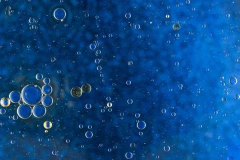 Abstract blue background with oil bubbles floating water surface Stock Photos