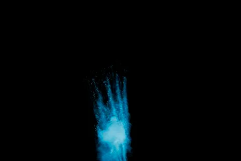 Abstract blue dust explosion on  black background. Stock Photos