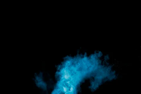 Abstract blue dust explosion on  black background. Stock Photos
