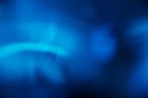 Abstract blue light leak texture background against a dark backdrop. Stock Photos