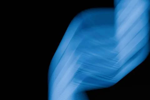 Abstract blue light trails sweep across a deep black background, creating a.. Stock-Illustration