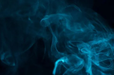 Abstract blue smoke on a dark background. Stock Photos