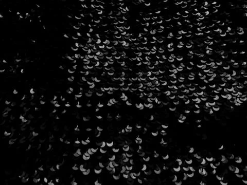 Abstract blurred background with black sequins. Gray and white elements on bl Stock Photos