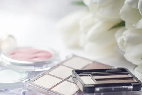 Abstract blurred background, cosmetics set and tulips on white. Macro shot, S Stock Photos