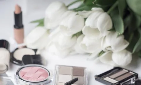 Abstract blurred background, cosmetics set and tulips on white. Macro shot, S Stock Photos