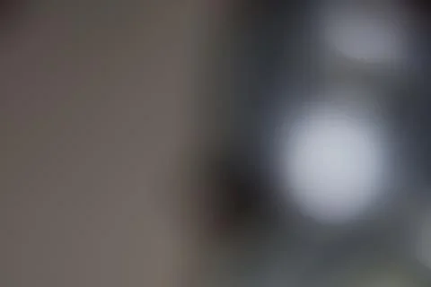 Abstract blurred background with soft light gradients and neutral dark grey.. Stock Photos