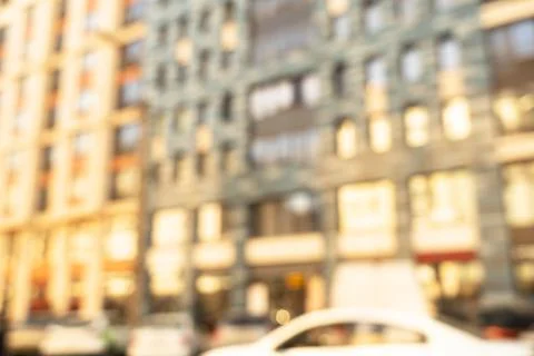 Abstract blurred building with illuminated facade exterior at the sunset. B.. Stock Photos