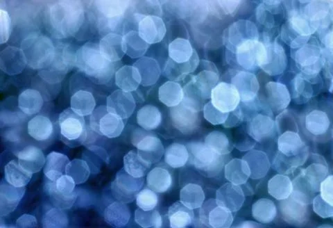 Abstract blurred glowing light particles of shades of light blue Stock Photos