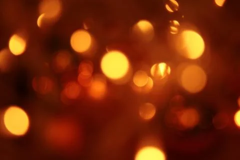 Abstract blurred glowing light particles of shades of light gold and red Stock Photos