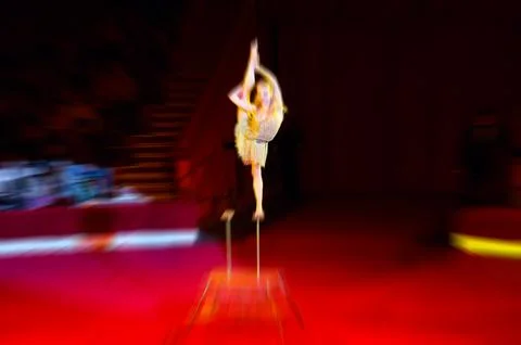 Abstract blurred image of circus performance. Flexible plastic young woman Stock Photos