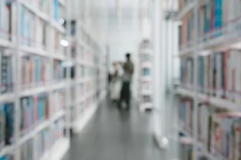 Abstract blurred image of library interior with tall bookshelves background Stock Photos