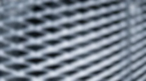 Abstract blurred metallic wire mesh texture featuring diagonal grid pattern.. Stock Photos