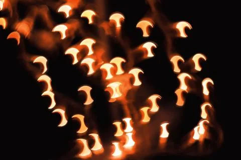 Abstract blurred orange light bokeh patterns against dark black background Stock Photos
