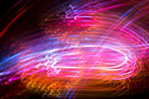 Abstract blurred space comet, multi-colored light lines on a black background Stock Photos