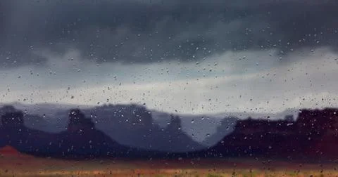 Abstract blurry background: view through the wet window Monument valley usa Stock Photos