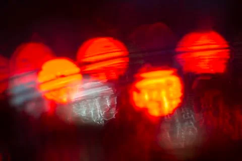 Abstract bokeh caused by rain drops reflecting onto car windscreen from car Stock Photos
