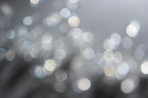 Abstract bokeh effect background in grey colours with rainbow rays. Stock Photos