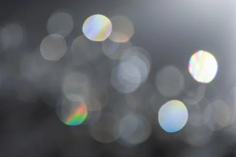 Abstract bokeh effect background in grey colours with rainbow rays. Stock Photos
